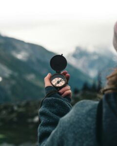 Individual pausing with compass in hand, reflecting on clear path forward