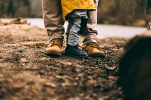 Parent figure walking through the woods with a child