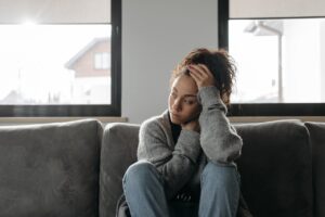 Person sitting quietly, visibly anxious before seeking legal protection